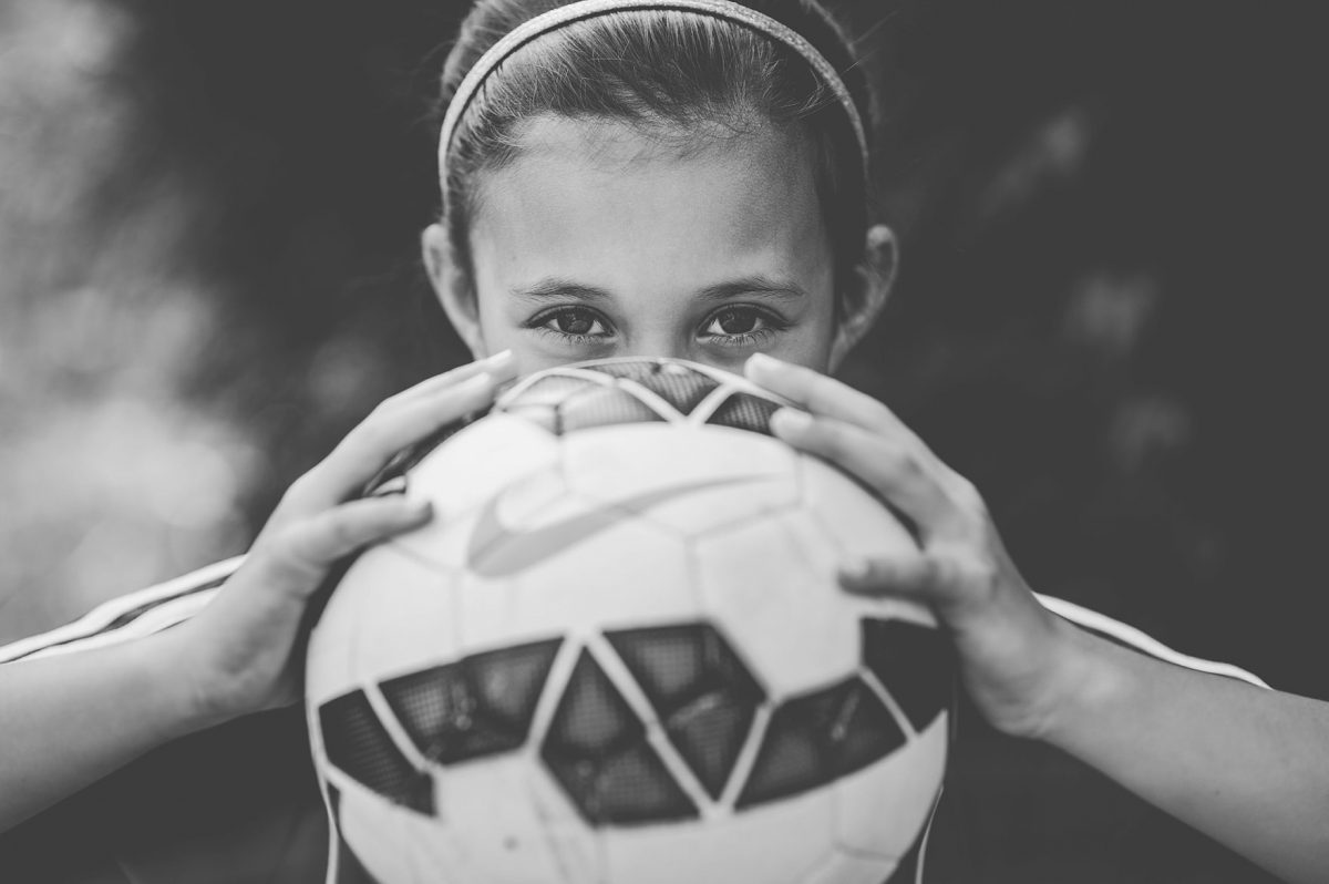 Photographers in Greensboro NC with tween girl peeking over soccer ball